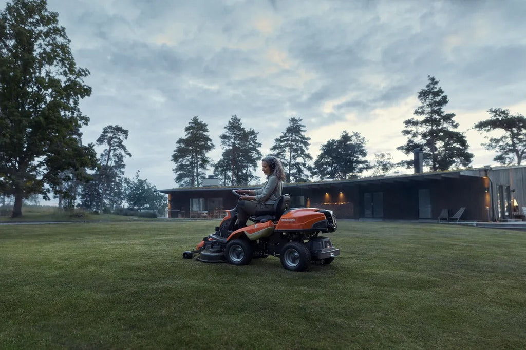 Woman using a Husqvarna lawn mower to cut the grass in the garden
